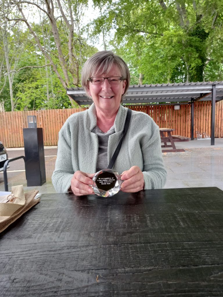 Sandra Mitchell receiving an award for five years' service as a volunteer community advocate